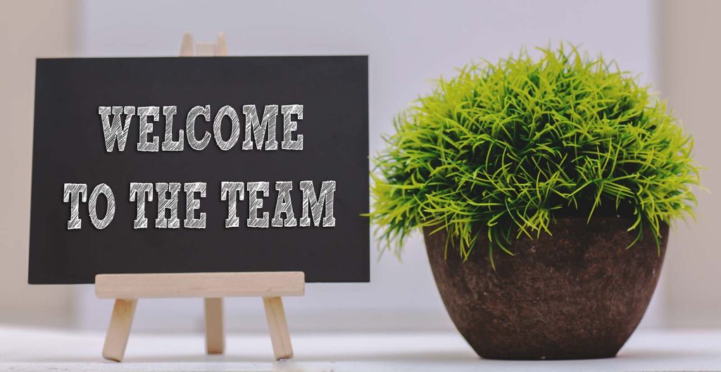 Image of a sign and plant to welcome a new employee